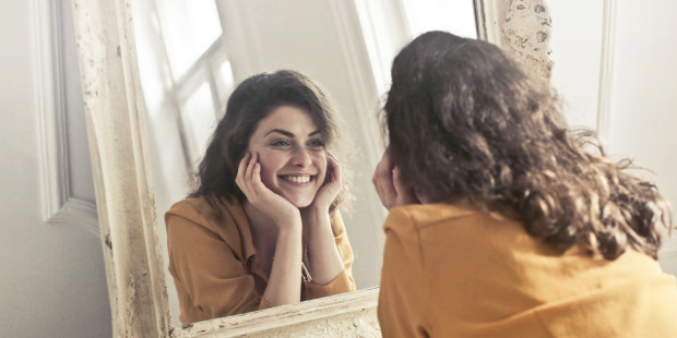 WOMAN LOOKING INTO MIRROR