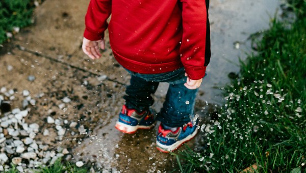 CHILD PLAYING IN PUDDLE