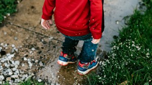 CHILD PLAYING IN PUDDLE