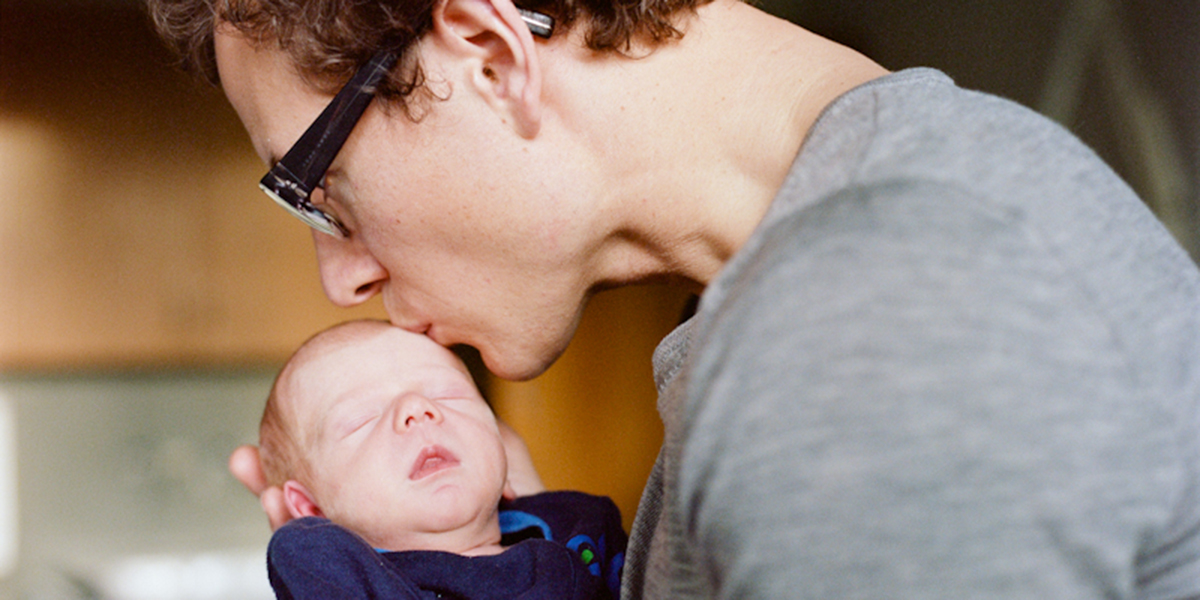 FATHER KISSING NEWBORN