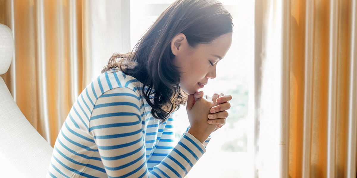 Young girl praying at home