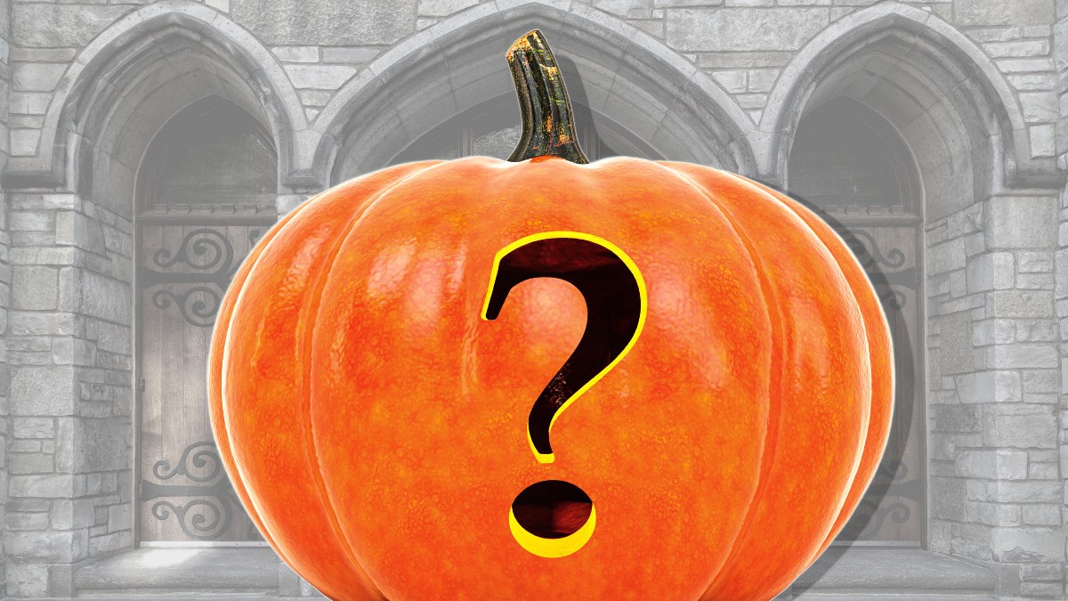Pumpkin carved with a question mark in front of a church