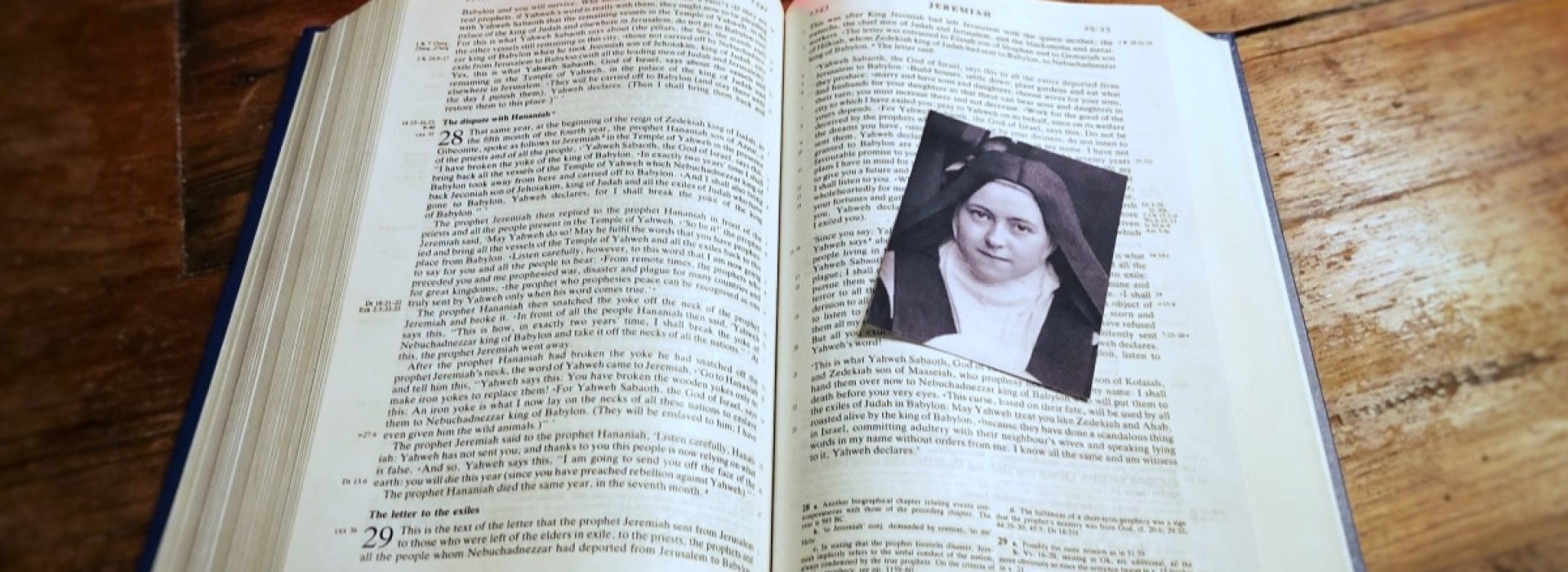Photo of St. Thérèse of Lisieux on Bible with red candle