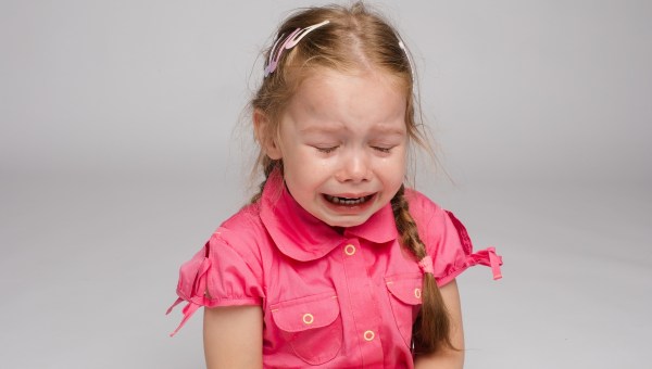 Little girl in pink shirt in tears