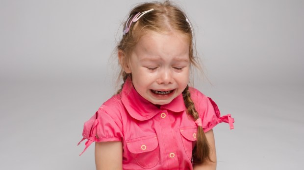 Little girl in pink shirt in tears