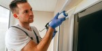Young man sealing windows