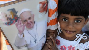 A young Sri Lankan holds paraphernalia bearing the portrait of Pope Francis – ar