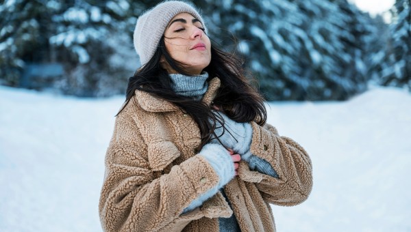 Relaxed woman breathing fresh air in a snowy winter mountain