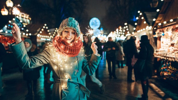 young woman with sparklers and Christmas lights