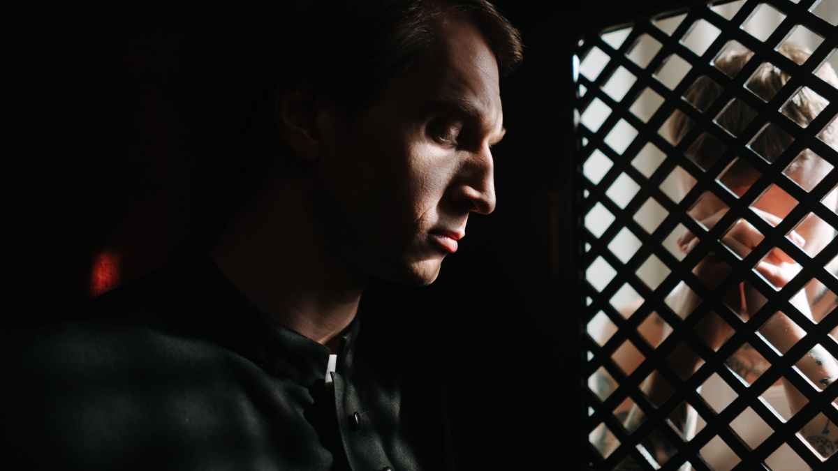 a priest listening to the person confessing