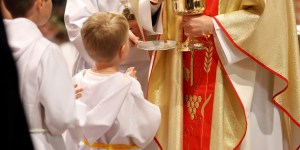 Why do some first communicants wear white robes?