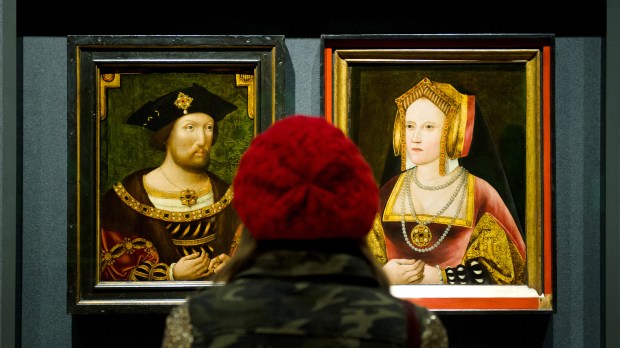 A woman looks at portraits of English King Henry VIII and his first wife Catherine of Aragon