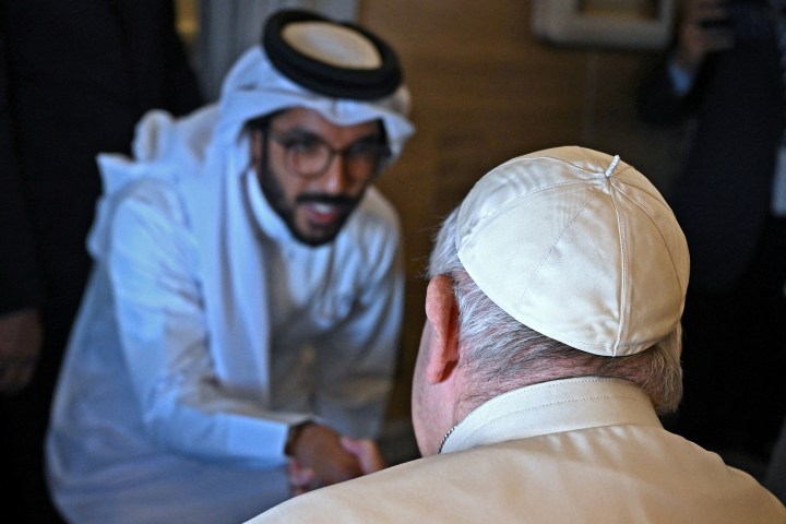 Pope-Francis-shakes-hands-with-a-journalist-from-his-seat-aboard-the-plane-from-Rome-to-Manama-AFP