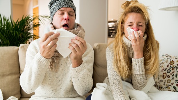 man and woman sitting on couch fighting illness