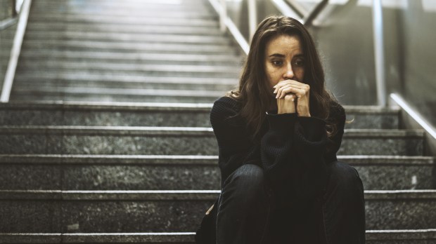 woman sitting on stairs looking worried