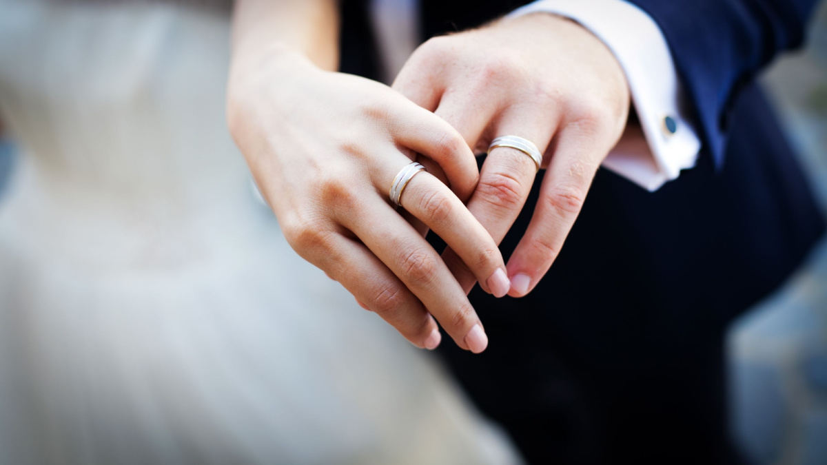 Beautiful couple holding hands showing wedding ring Stock Photo | Adobe  Stock