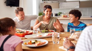 Family sitting around table eating dinner