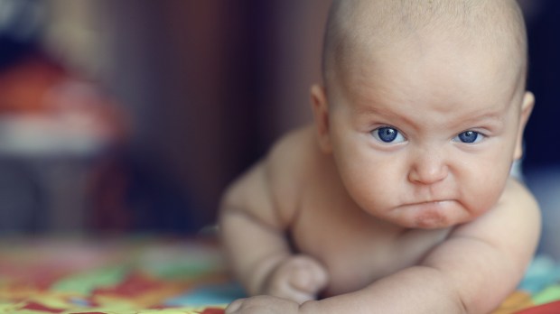 baby pounding table with stern face