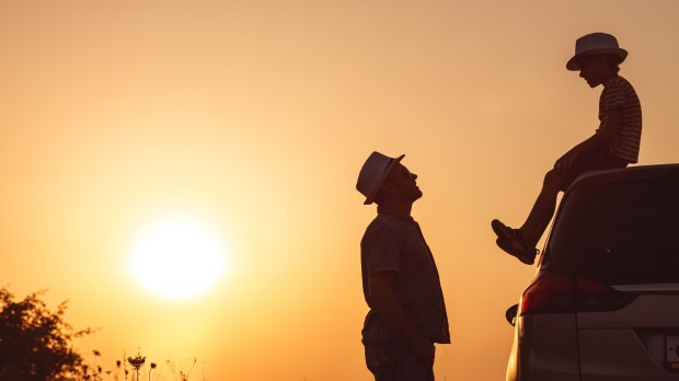 Father and son enjoy a sunset together