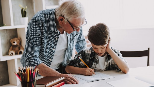 Grandson-Doing-School-Homework-with-Old-Man-Home.-shutterstock