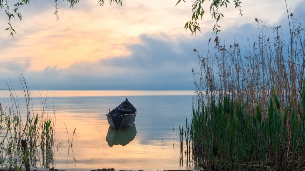 Old rowboat on the lake at sunset