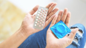 Contraceptives condom pills hands