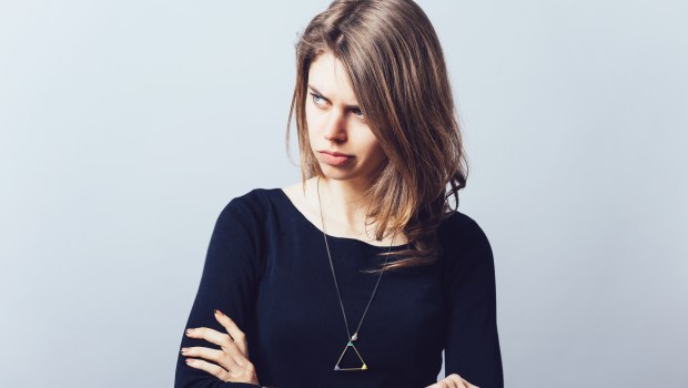 Woman with arms folded looking irritated