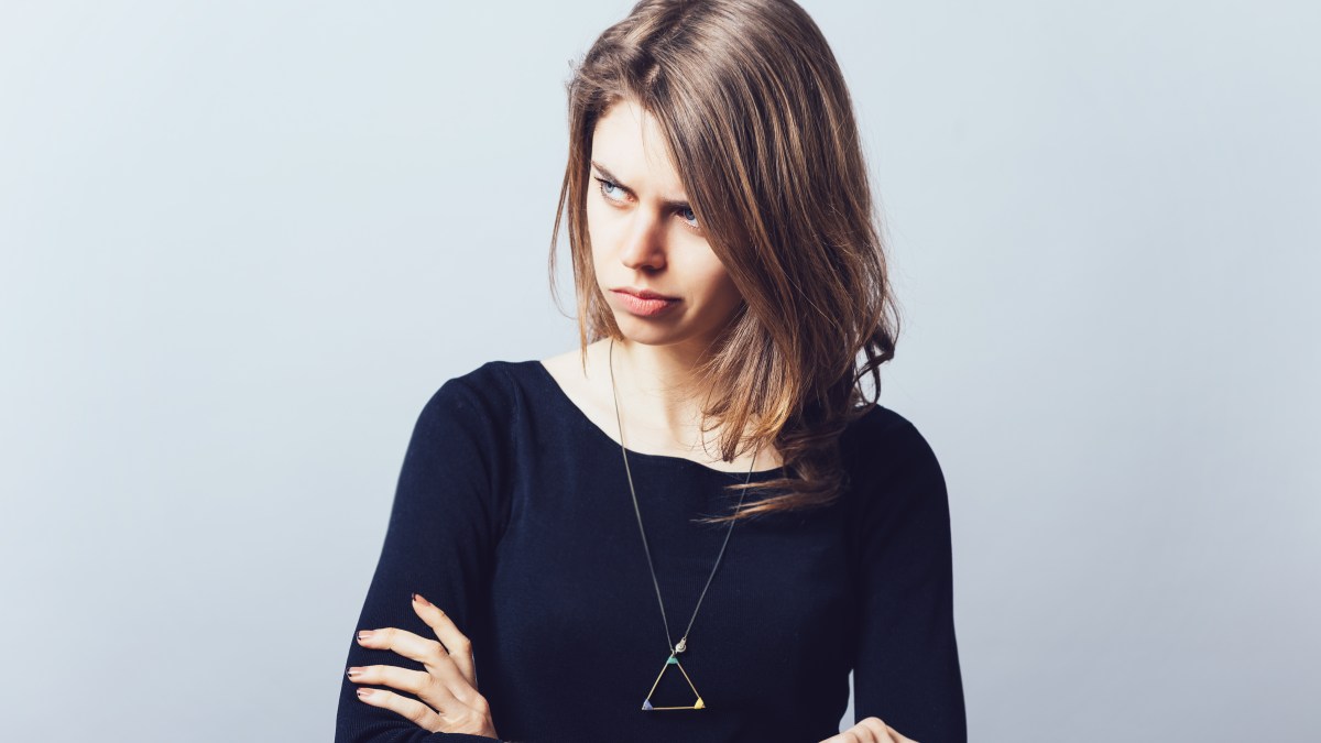 Woman with arms folded looking irritated