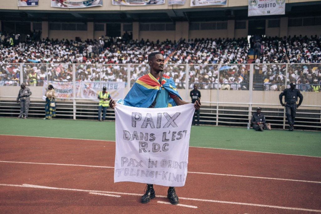 A man draped with a Democratic Republic of Congo-Pope Francis meets with young people and catechists at Martyrs' Stadium in Kinshasa