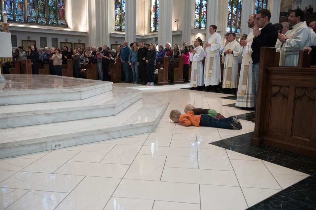 two boys and a dad at ordination in Denver cathedral