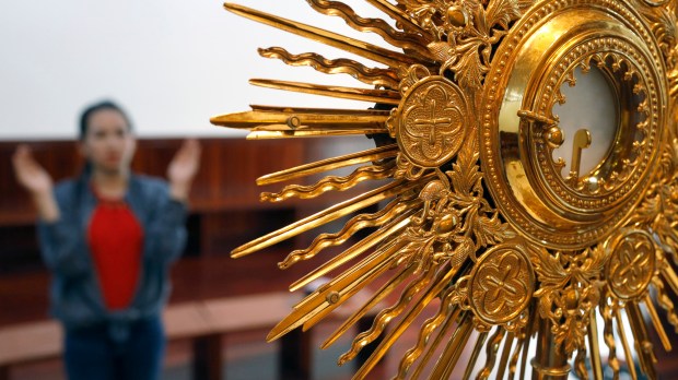 Woman prays before monstrance