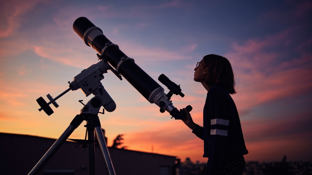 Kid with telescope at sunset