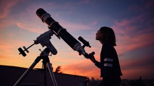 Kid with telescope at sunset