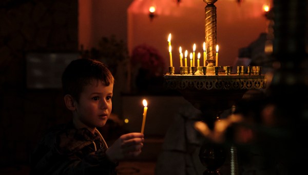 child-holding-candle-church