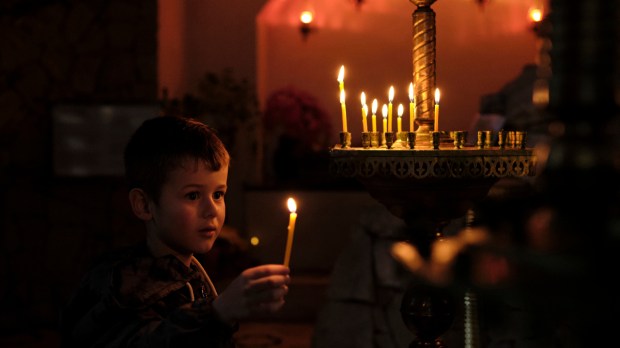 child-holding-candle-church