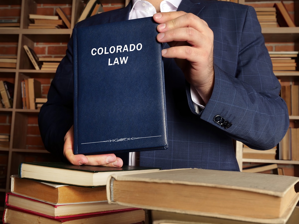 Colorado law book held by man