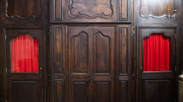 Exterior view of old confessional with red curtains