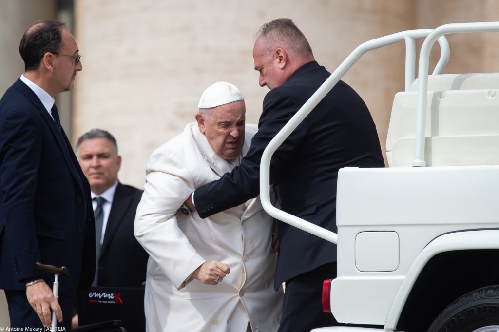 Pope Francis is helped get up the popemobile car as he leaves