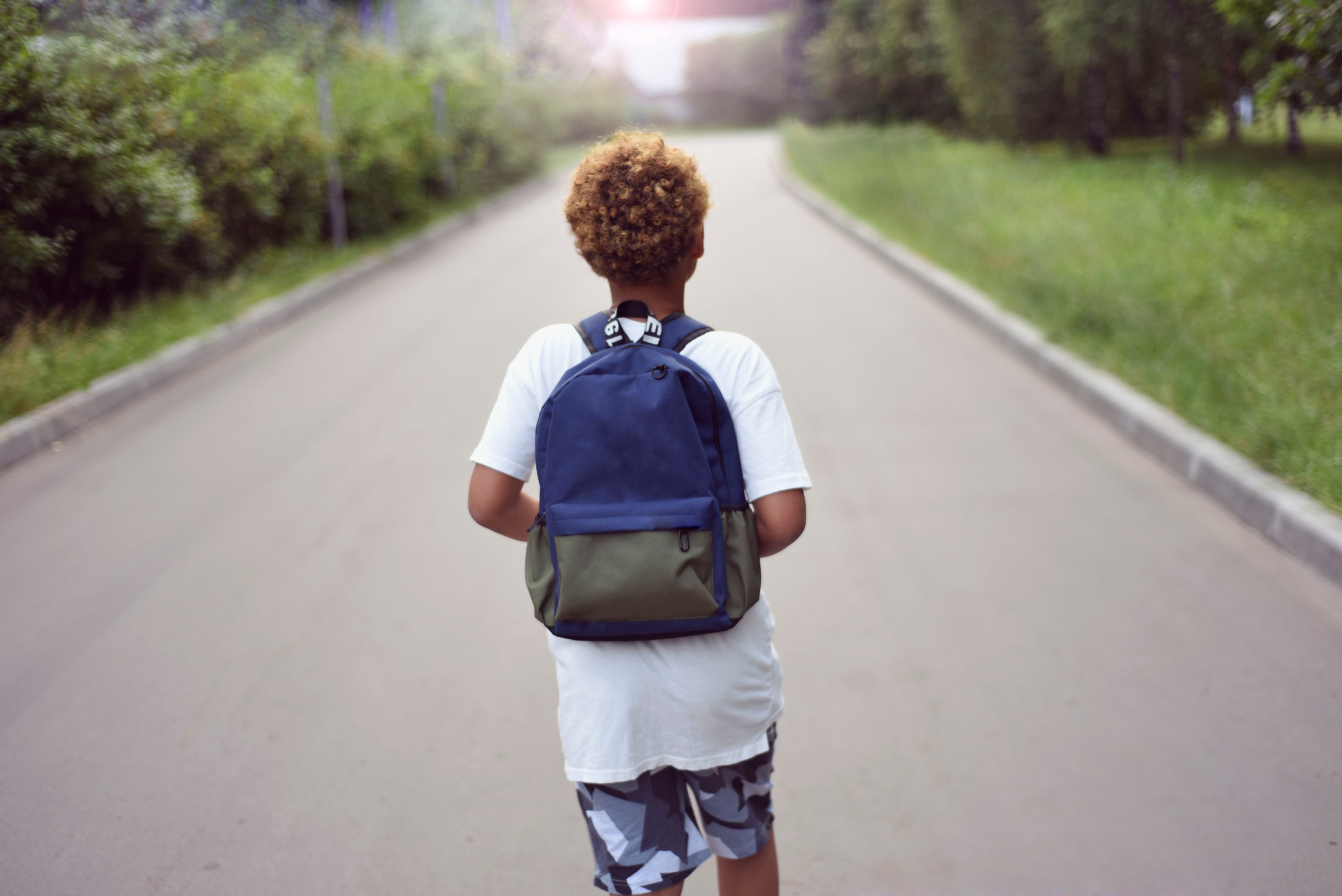 American boy walking to school with backpack