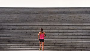 sporty woman running up stairs