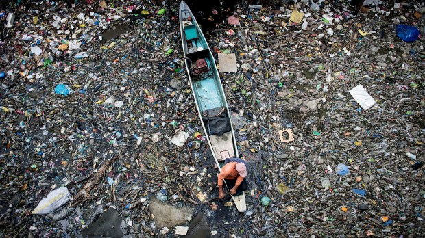 A worker collects garbage from the Marilao River in Bulacan north of Manila