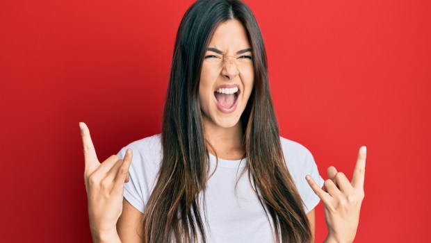 Adolescent girl making a face an ambiguous hand gesture that can be devil horns or have another less nefarious meaning