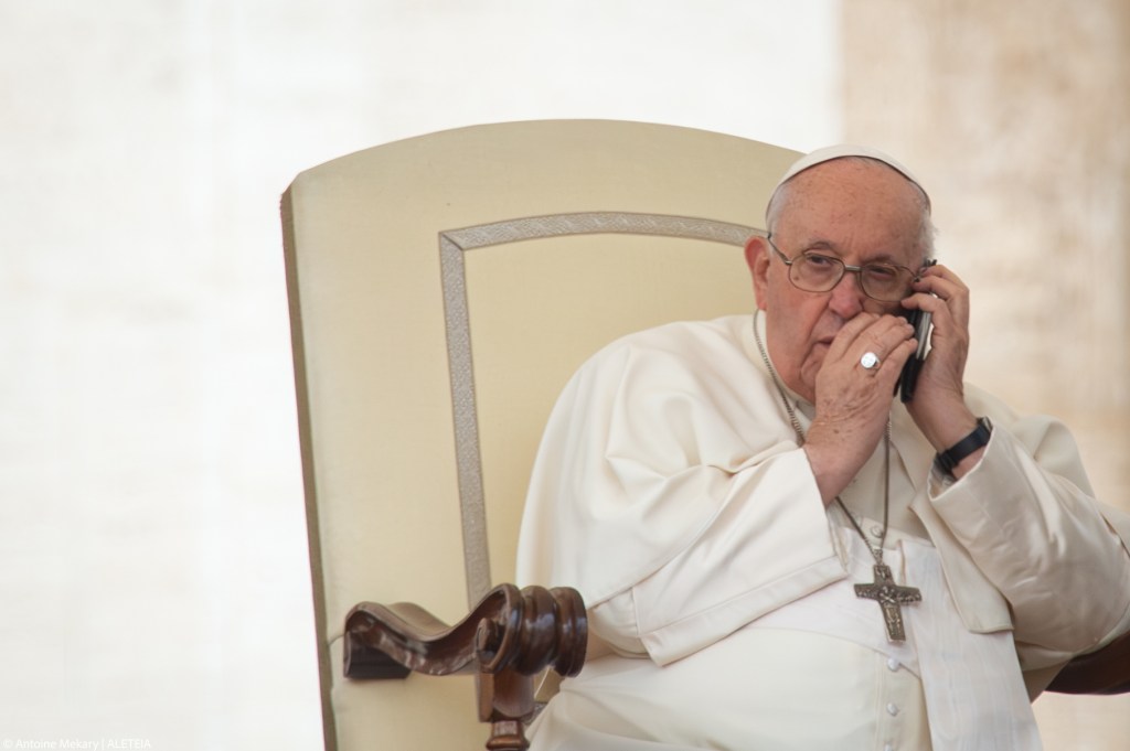 Pope Francis speaks on the phone during the weekly general audience