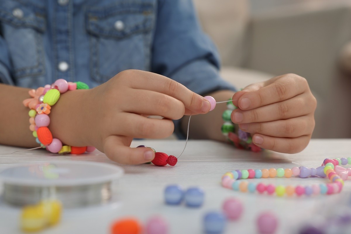 Little Girl making Bead bracelets