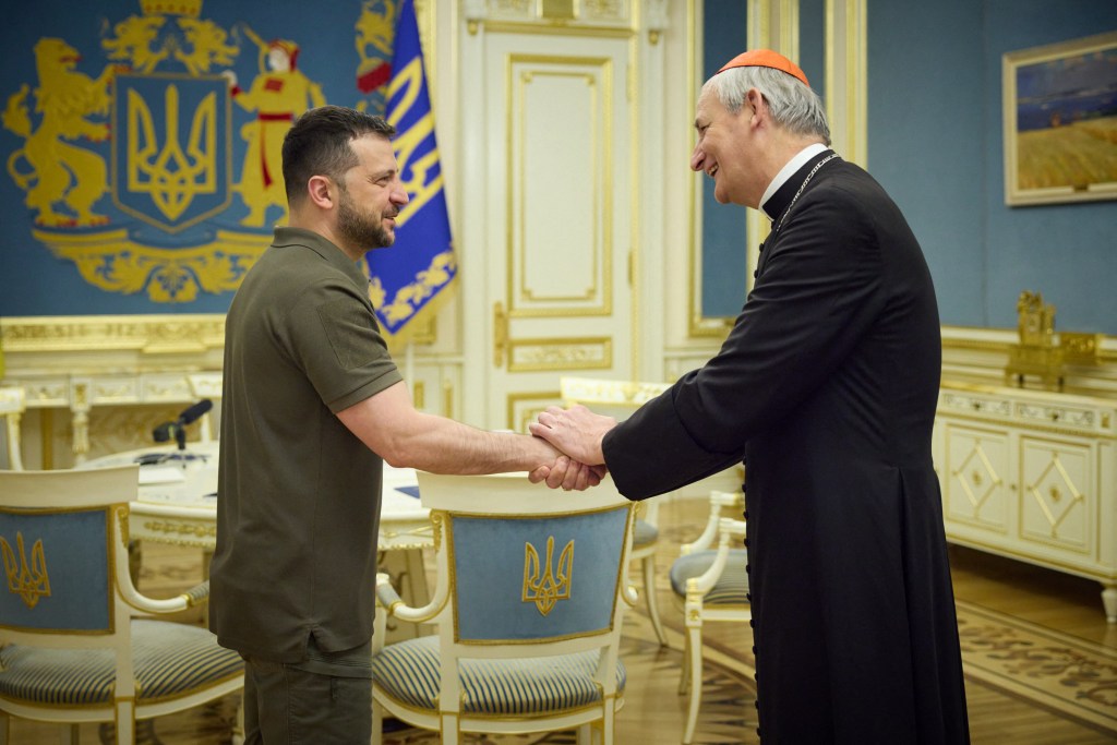 Ukrainian President Volodymyr Zelensky shaking hands with Pope Francis' peace envoy to Ukraine Cardinal Matteo Zuppi