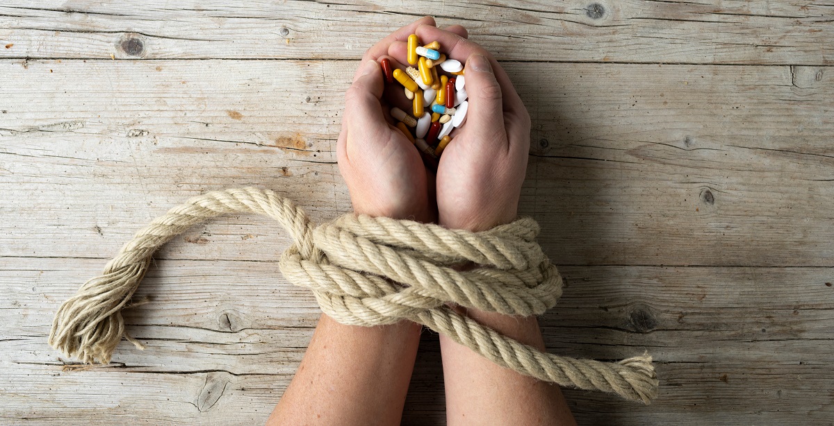 addiction, hands tied with drugs