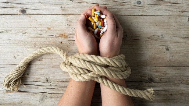 addiction, hands tied with drugs