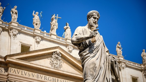 The statue of St. Peter in St. Peter's square with part of the façade of the basilica visible behind