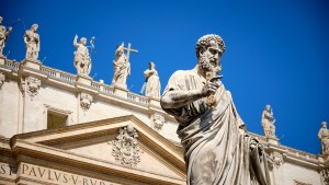 The statue of St. Peter in St. Peter's square with part of the façade of the basilica visible behind