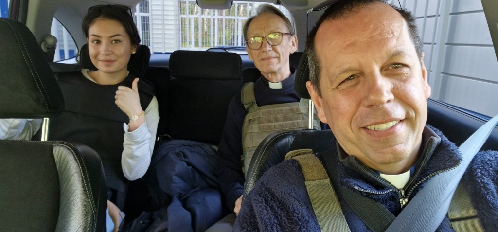 Two priests and a woman in a car